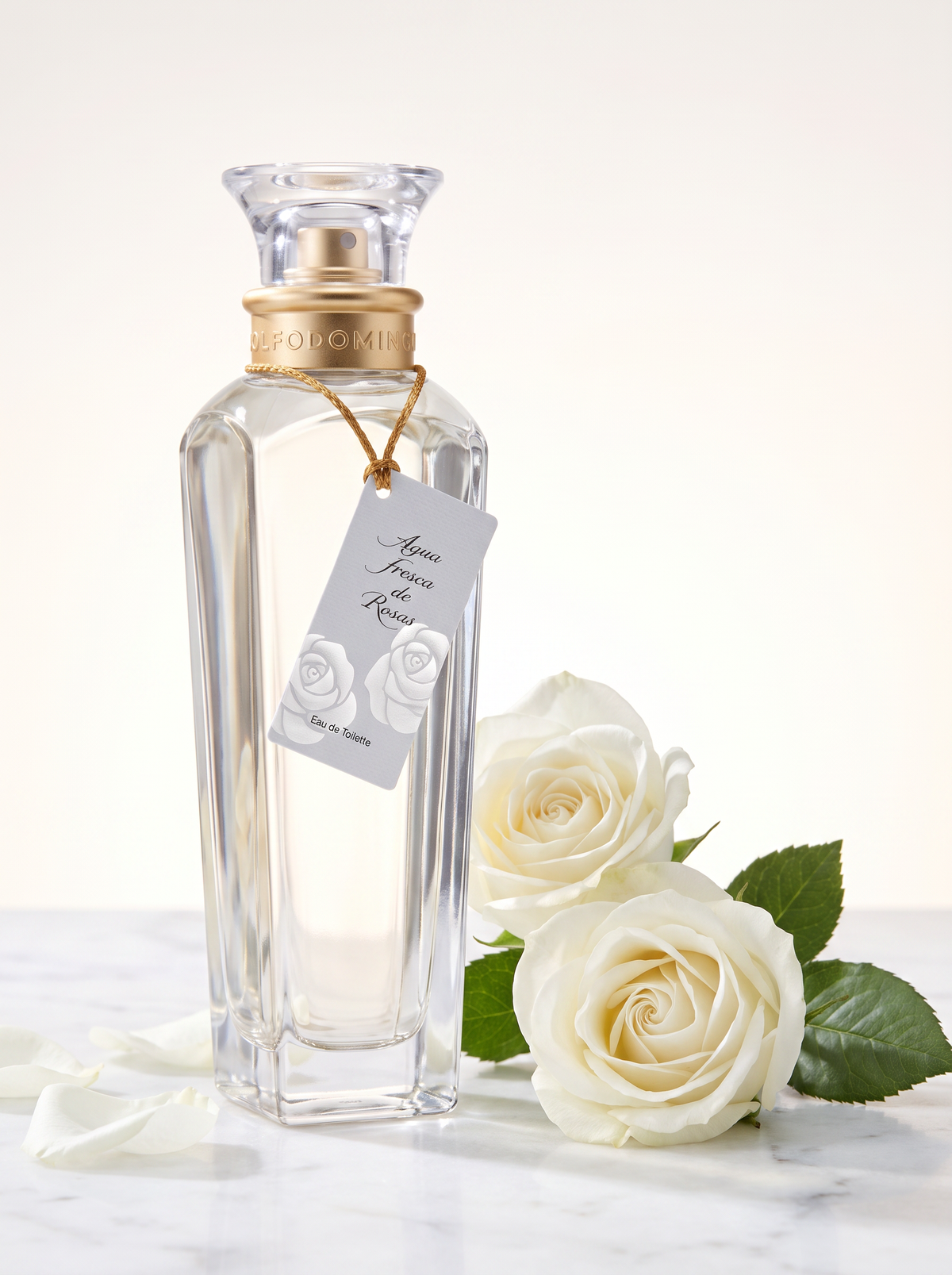 Adolfo Dominguez Agua Fresca de Rosas Eau de Toilette 60 ml - Flakon mit Anhaenger auf hellem Marmor mit weissen Rosen