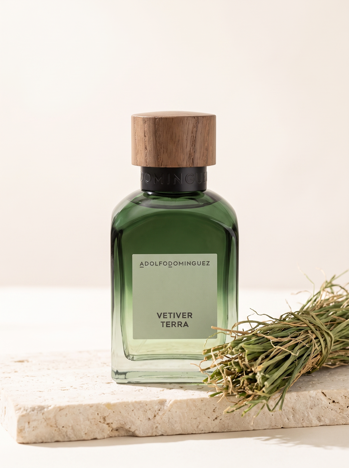 Adolfo Dominguez Vetiver Terra Eau de Parfum 120 ml - gruener Flakon mit Holzdeckel auf hellem Stein mit Vetivergras