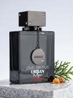 Armaf Club de Nuit Urban Man Elixir Eau de Parfum 105 ml - Flakon auf hellem Granit mit Zedernzweig