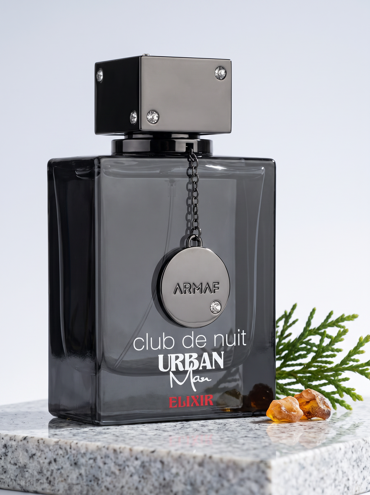 Armaf Club de Nuit Urban Man Elixir Eau de Parfum 105 ml - Flakon auf hellem Granit mit Zedernzweig
