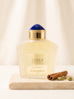 Boucheron Jaipur Homme Eau de Parfum 100 ml - Flakon mit blauer Kappe auf hellem Sandstein mit Zimt und Kardamom