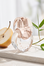 Bvlgari Omnia Crystalline Eau de Toilette Flakon auf hellem Stein mit Nashi-Birne und Bambus - kaufenparfum.de