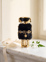Rabanne Fame The Couture Edition Eau de Parfum - goldener Figur-Flakon mit Pelzkragen auf weissem Marmor