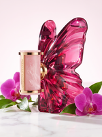Carolina Herrera La Bomba Eau de Parfum 80 ml - Schmetterlingsflakon auf hellem Marmor mit pinken Orchideen