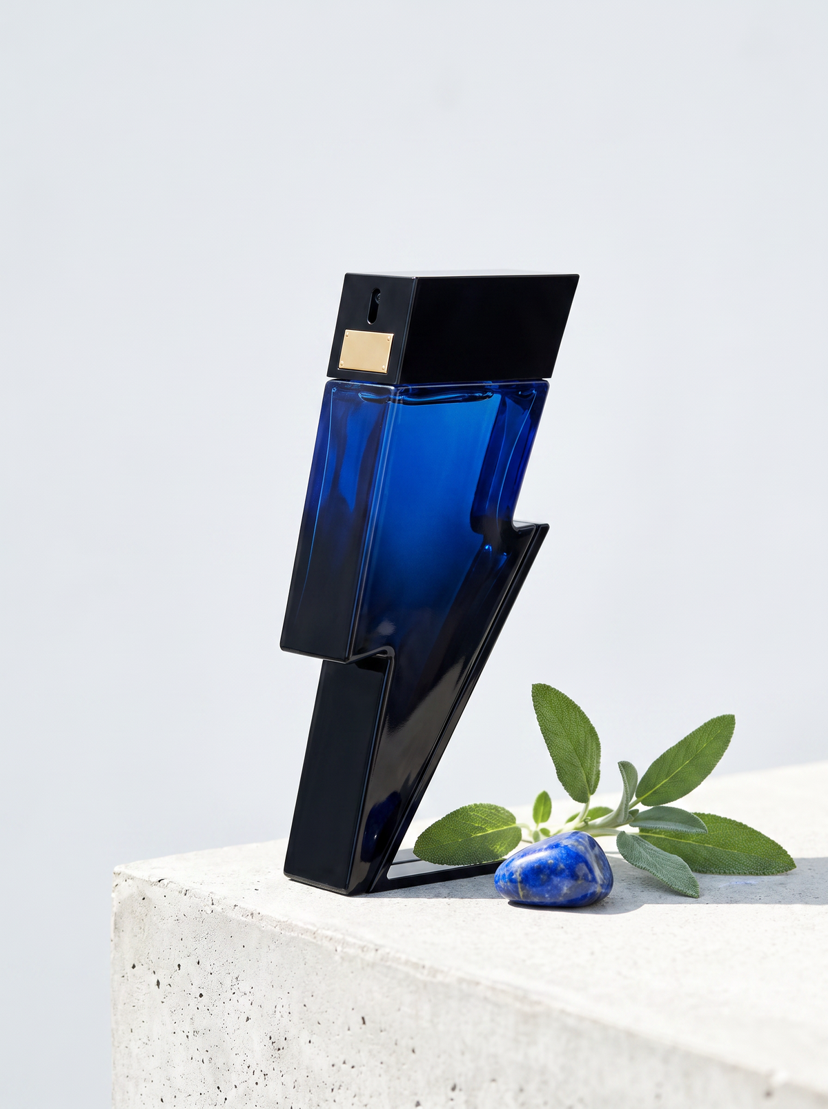 Carolina Herrera Bad Boy Cobalt Eau de Parfum 50 ml - Blitz-Flakon auf hellem Beton mit Lapislazuli und Salbei