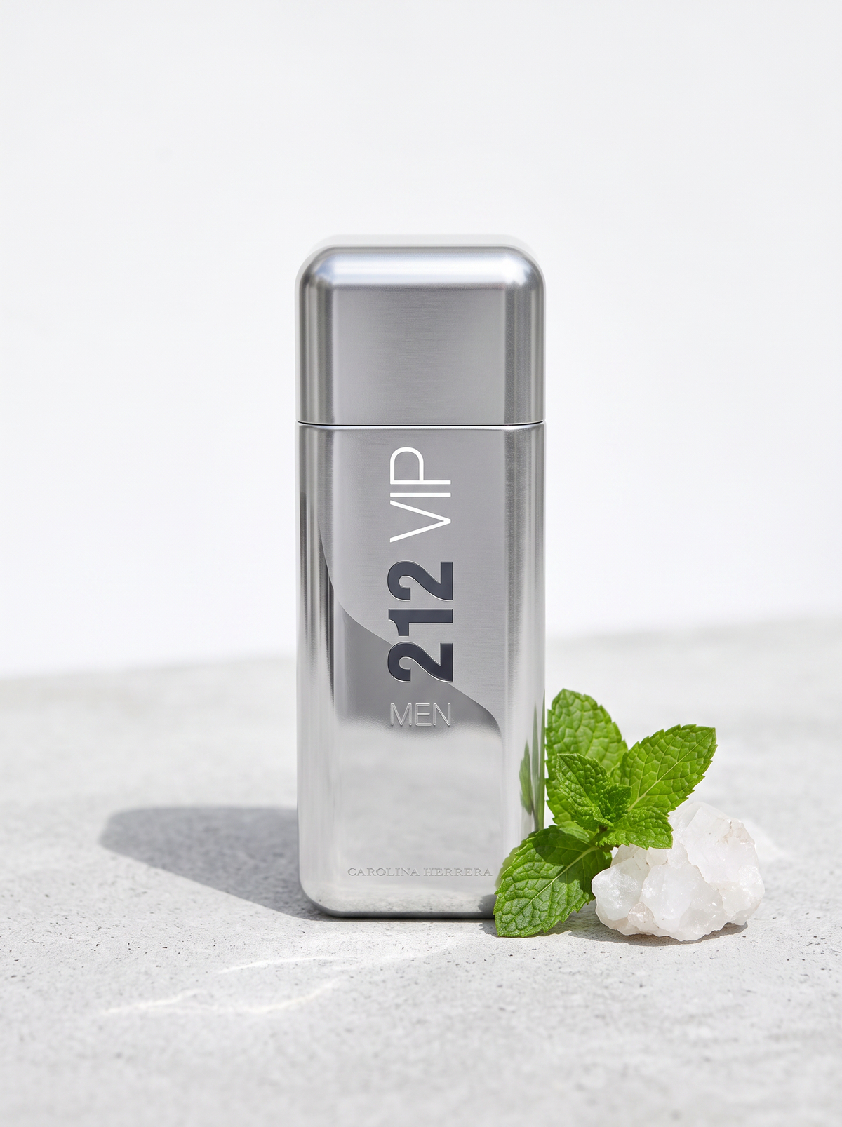 Carolina Herrera 212 VIP Men Eau de Toilette 100 ml - silberner Flakon auf hellem Beton mit Minze