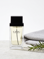 Carolina Herrera Chic for Men Eau de Toilette 100 ml - klarer Flakon auf hellem Stein mit Rosmarin