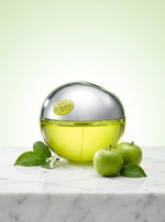 DKNY Be Delicious Eau de Parfum 100 ml - Apfel-Flakon auf hellem Marmor mit gruenen Aepfeln