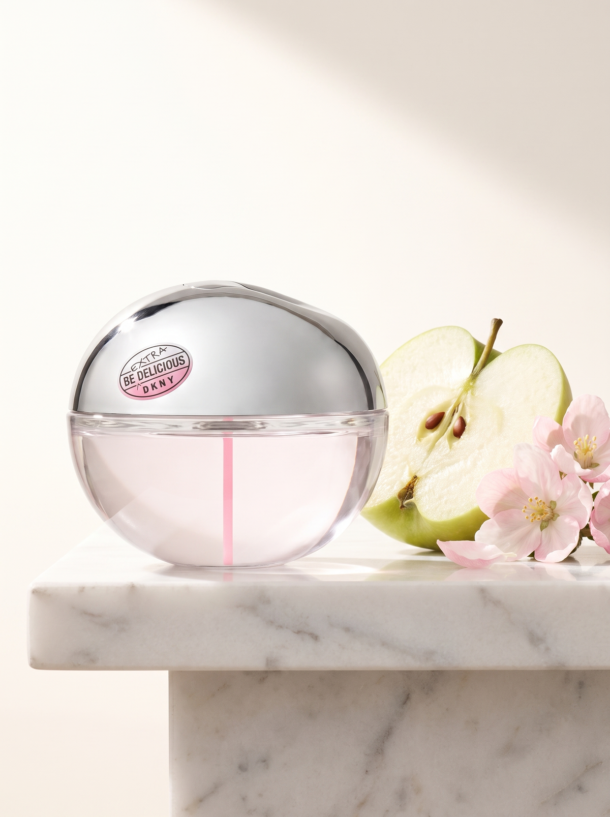 DKNY Be Extra Delicious Eau de Parfum 100 ml - Apfel-Flakon auf weissem Marmor mit Apfel und Blueten