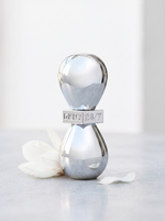 DKNY 24/7 Eau de Parfum 50 ml - Chrom-Flakon auf hellem Beton mit weisser Magnolie