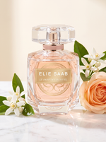 Elie Saab Le Parfum Essentiel Eau de Parfum 90 ml - facettierter Flakon auf weissem Marmor mit Orangenbluete und Rose