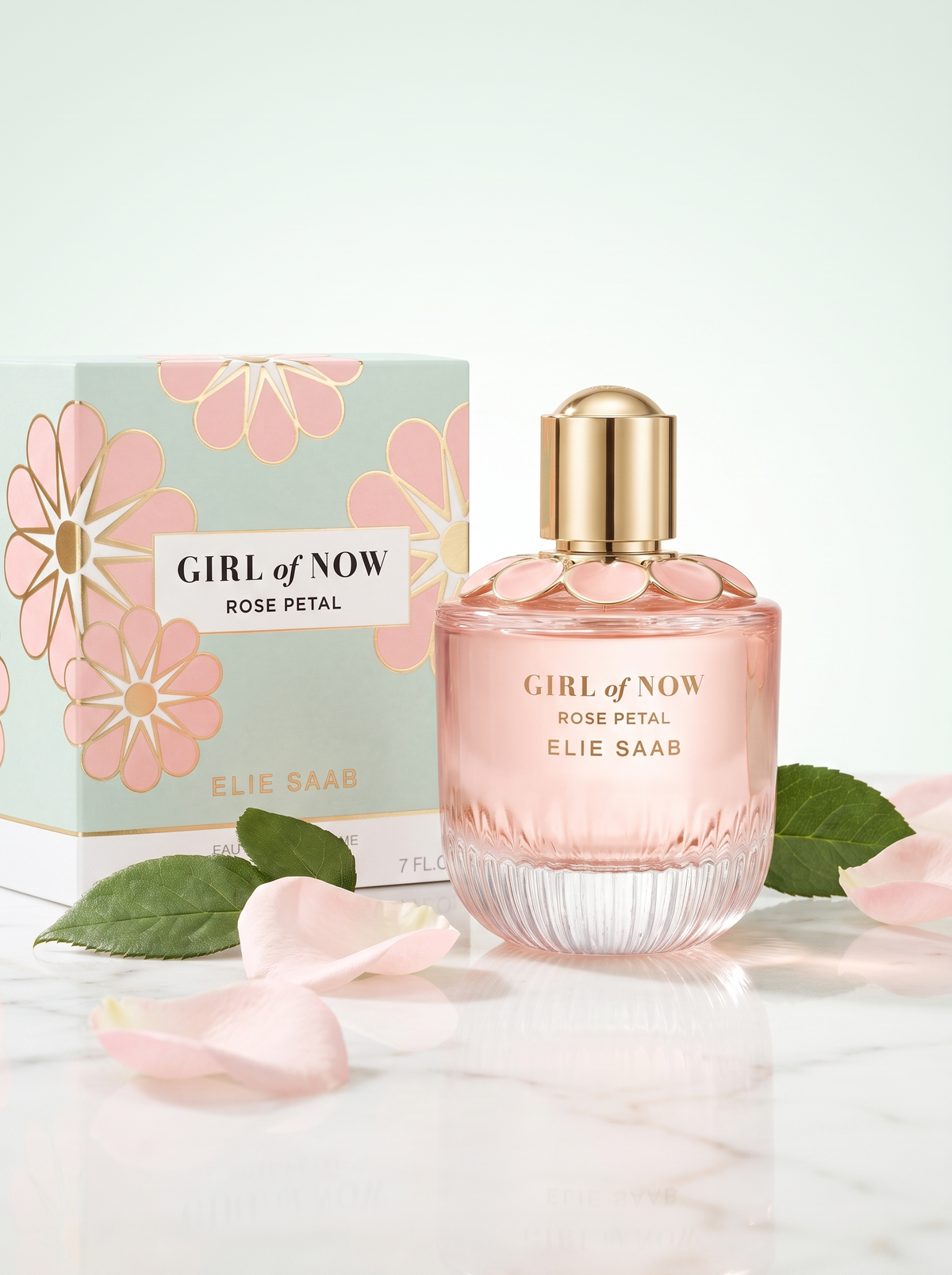 Elie Saab Girl of Now Rose Petal Eau de Parfum 90 ml - rosa Flakon mit Verpackung auf hellem Marmor mit Rosenblaettern