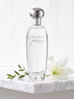 Estee Lauder Pleasures Eau de Parfum 50 ml - klarer Flakon auf weissem Marmor mit weisser Lilie