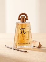 Givenchy Pi Eau de Toilette 100 ml - Flakon auf hellem Eichenholz mit Vanilleschote und Zedernholz