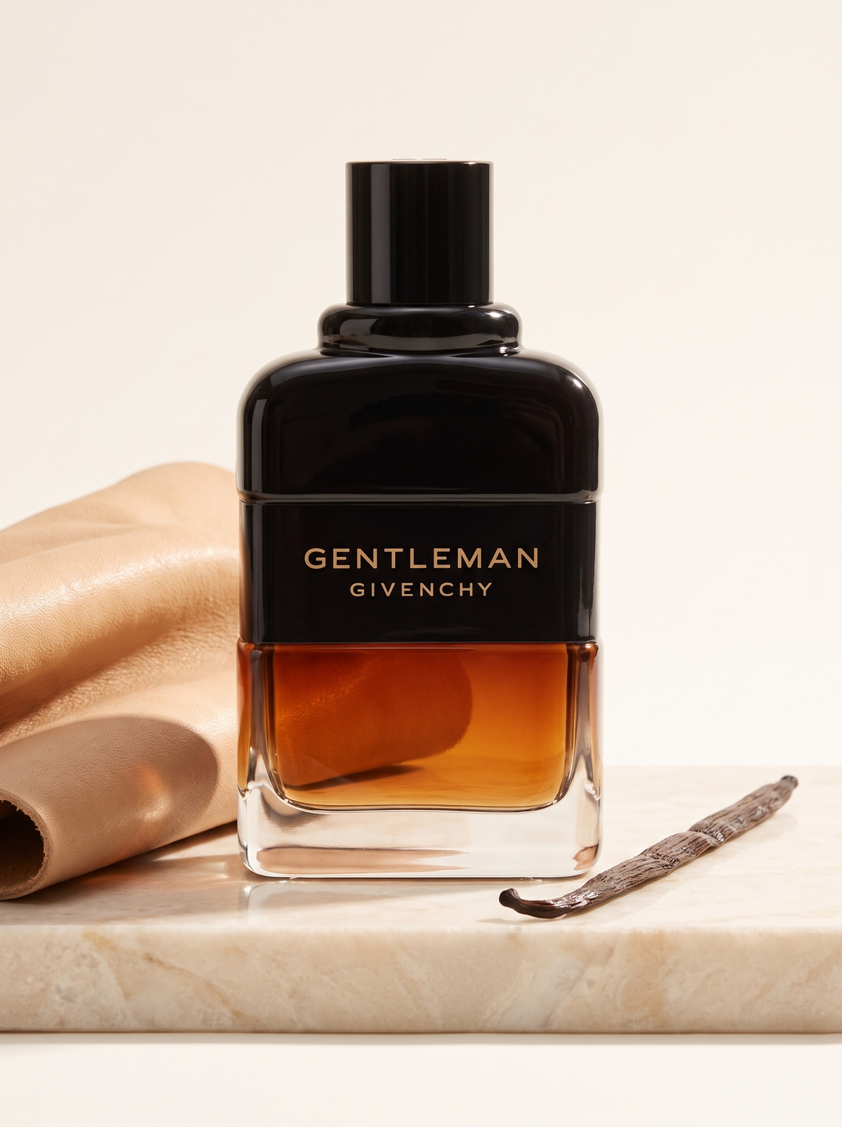 Givenchy Gentleman Reserve Privee Eau de Parfum 100 ml - Flakon auf hellem Marmor mit Leder und Vanilleschote