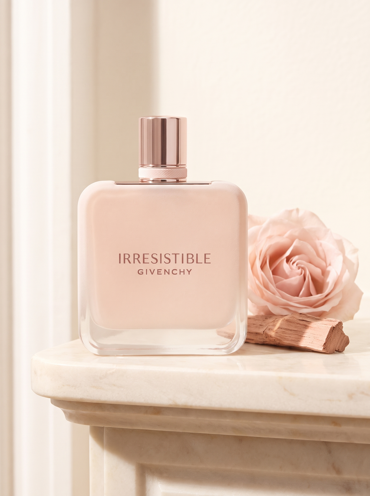 Givenchy Irresistible Velvet Eau de Parfum 80 ml - pudriger Flakon auf hellem Marmor mit Rose und Rosenholz