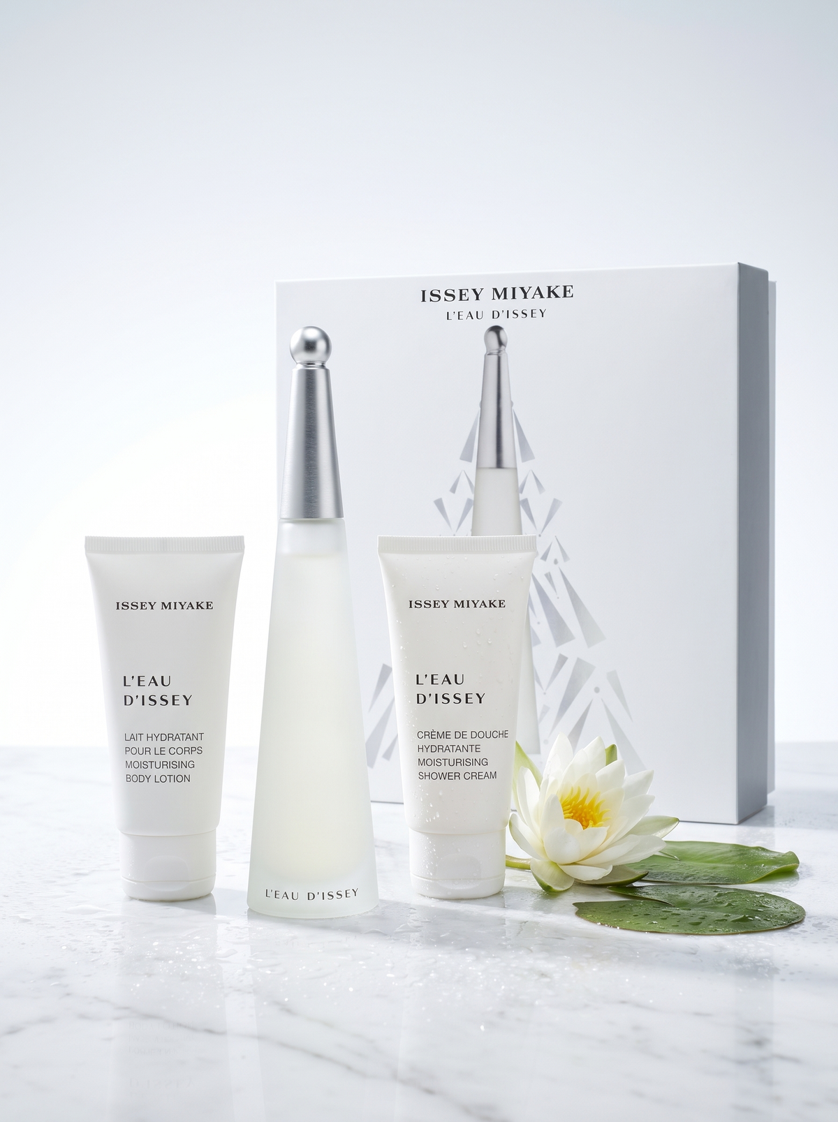 Issey Miyake L Eau d Issey Geschenkset 3-teilig - Flakon Bodylotion und Duschcreme auf hellem Marmor mit Seerose