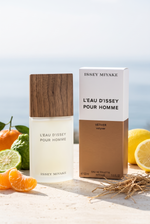 Issey Miyake L'Eau d'Issey Pour Homme Vetiver Eau de Toilette mit Verpackung auf sonniger Terrasse mit Zitrusfruechten und Vetiverwurzeln - kaufenparfum.de