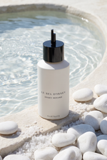 Issey Miyake Le Sel d Issey Eau de Toilette Nachfuellung 150 ml - Flakon am Rand einer klaren Mineralquelle mit weissen Kieseln