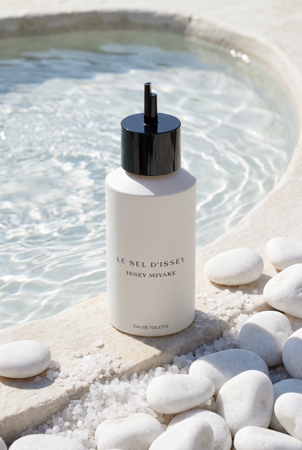 Issey Miyake Le Sel d Issey Eau de Toilette Nachfuellung 150 ml - Flakon am Rand einer klaren Mineralquelle mit weissen Kieseln