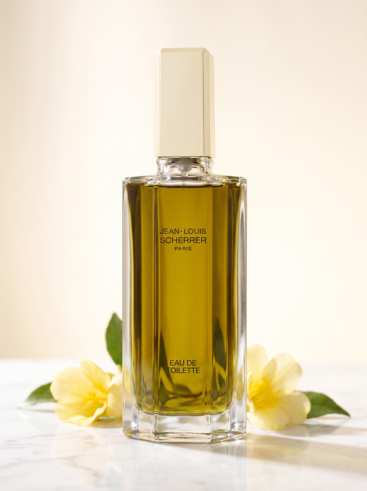 Jean-Louis Scherrer Eau de Toilette 100 ml - facettierter Flakon auf hellem Marmor mit gelben Blueten