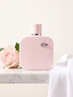 Lacoste L.12.12 Rose Eau de Parfum 100 ml - rosa Pique-Flakon auf weissem Marmor mit Rose