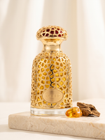 Lattafa Emeer Eau de Parfum 100 ml - goldener Filigran-Flakon auf hellem Marmor mit Oudholz und Bernstein