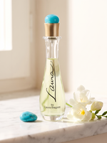Laura Biagiotti Laura Eau de Toilette 75 ml - Flakon mit tuerkiser Kappe auf weissem Marmor mit Freesien