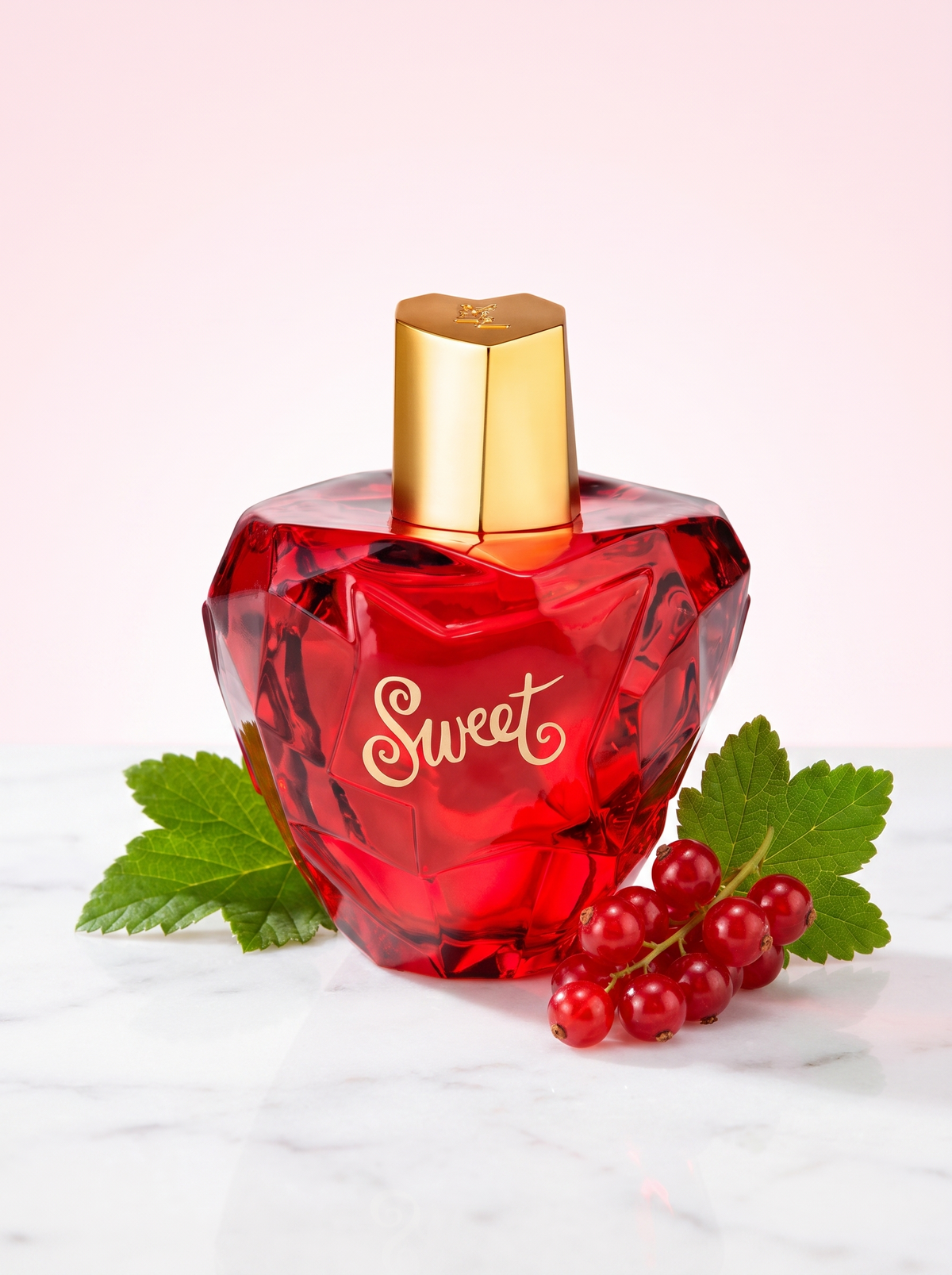 Lolita Lempicka Sweet Eau de Parfum 100 ml - roter Apfelflakon auf hellem Marmor mit roten Johannisbeeren