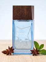Lempicka Homme Eau de Toilette 100 ml - eisblauer Flakon mit Holzdeckel auf hellem Holz mit Sternanis