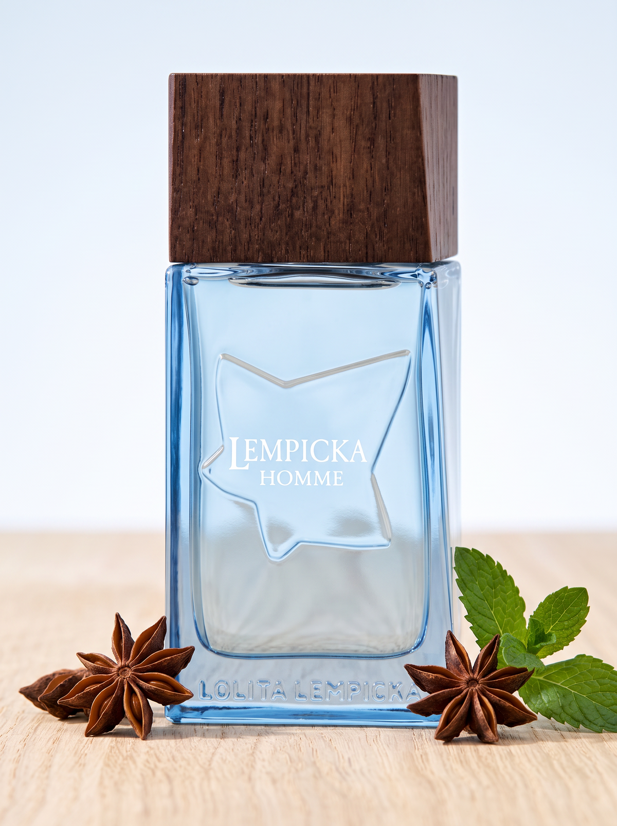 Lempicka Homme Eau de Toilette 100 ml - eisblauer Flakon mit Holzdeckel auf hellem Holz mit Sternanis
