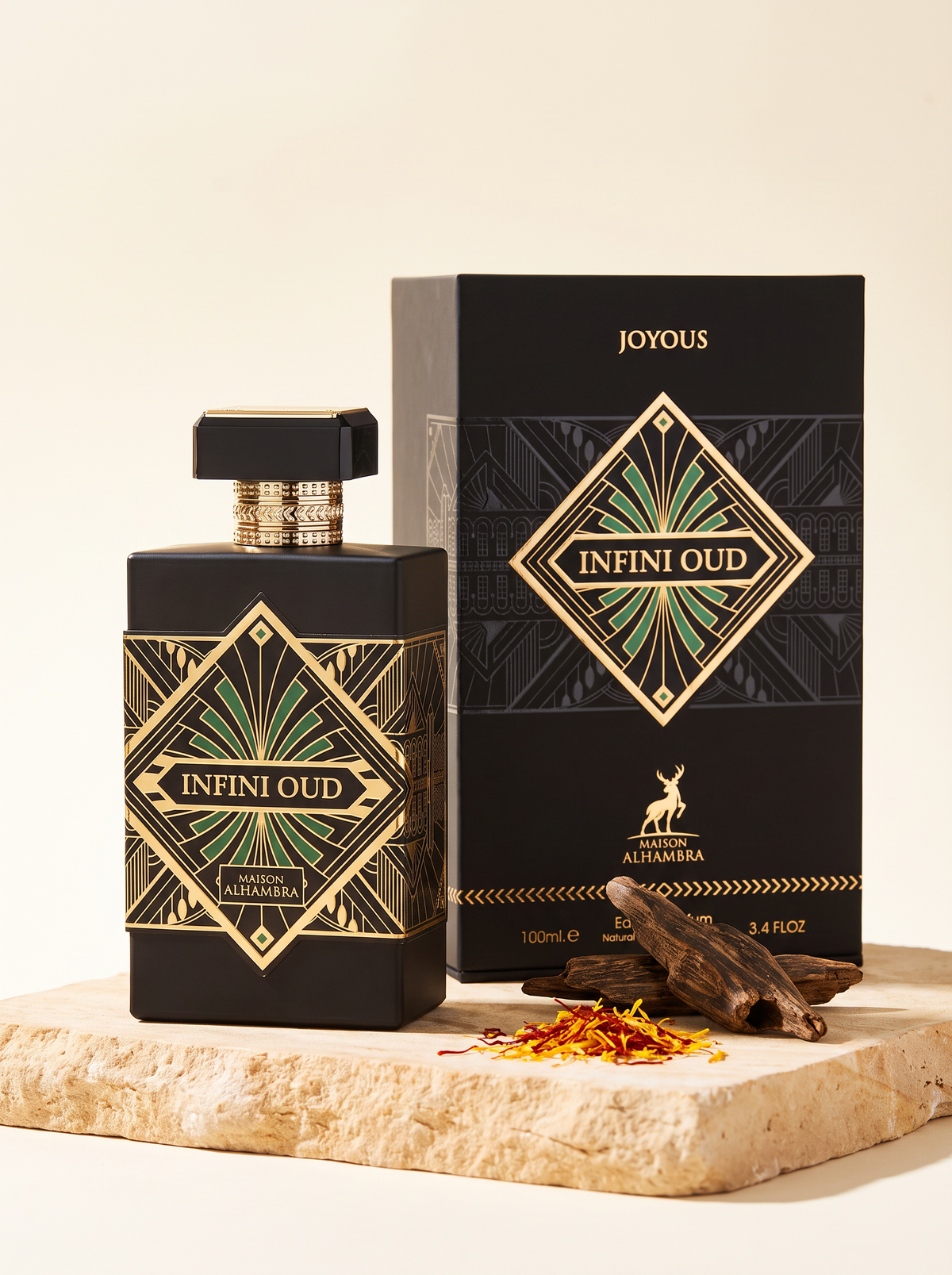 Maison Alhambra Joyous Infini Oud Eau de Parfum 100 ml - schwarzer Flakon mit Verpackung auf Sandstein mit Oudholz und Safran