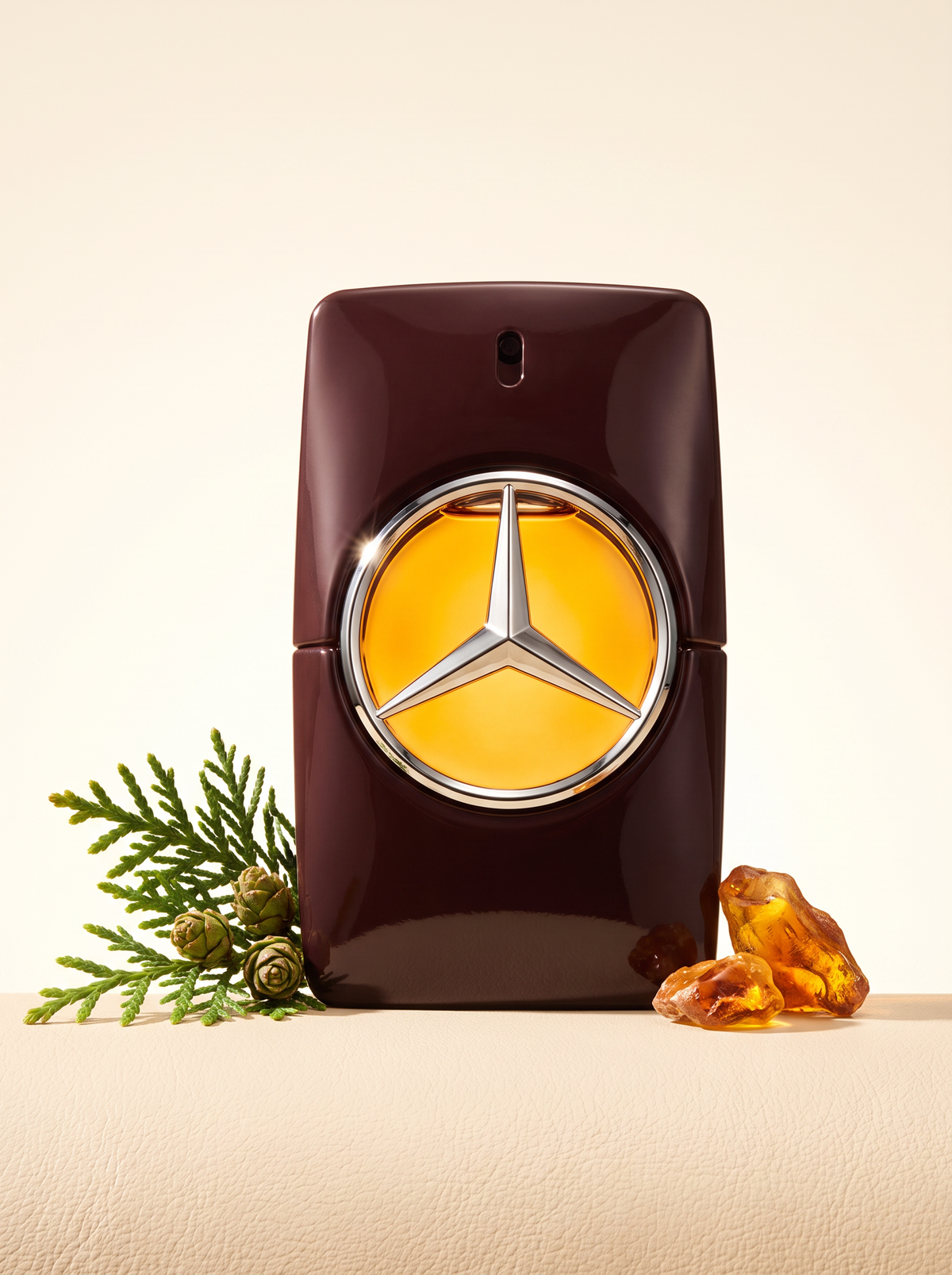 Mercedes-Benz for Men Eau de Parfum 100 ml - bordeauxfarbener Flakon auf hellem Leder mit Zeder und Bernstein
