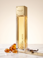 Michael Kors Sexy Amber Eau de Parfum 100 ml - goldener Flakon auf hellem Marmor mit Bernstein und Vanille