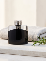 Montblanc Legend Eau de Toilette 50 ml - schwarz-chrom Flakon auf hellem Stein mit Rosmarin