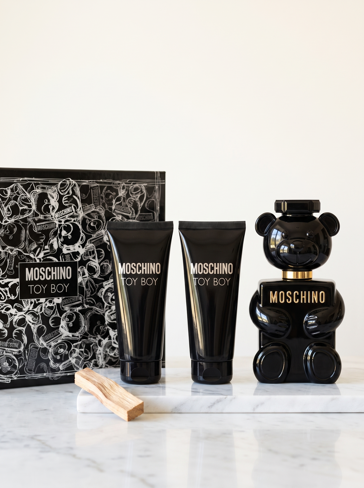 Moschino Toy Boy Geschenkset - schwarzer Baerchen-Flakon mit Duschgel und Bodylotion auf weissem Marmor