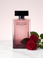Narciso Rodriguez Musc Noir Rose Eau de Parfum 100 ml - Flakon auf hellem Marmor mit dunkelroten Rosen