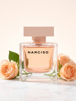 Narciso Rodriguez Narciso Cristal Eau de Parfum 90 ml - Flakon auf hellem Marmor mit pfirsichfarbenen Rosen