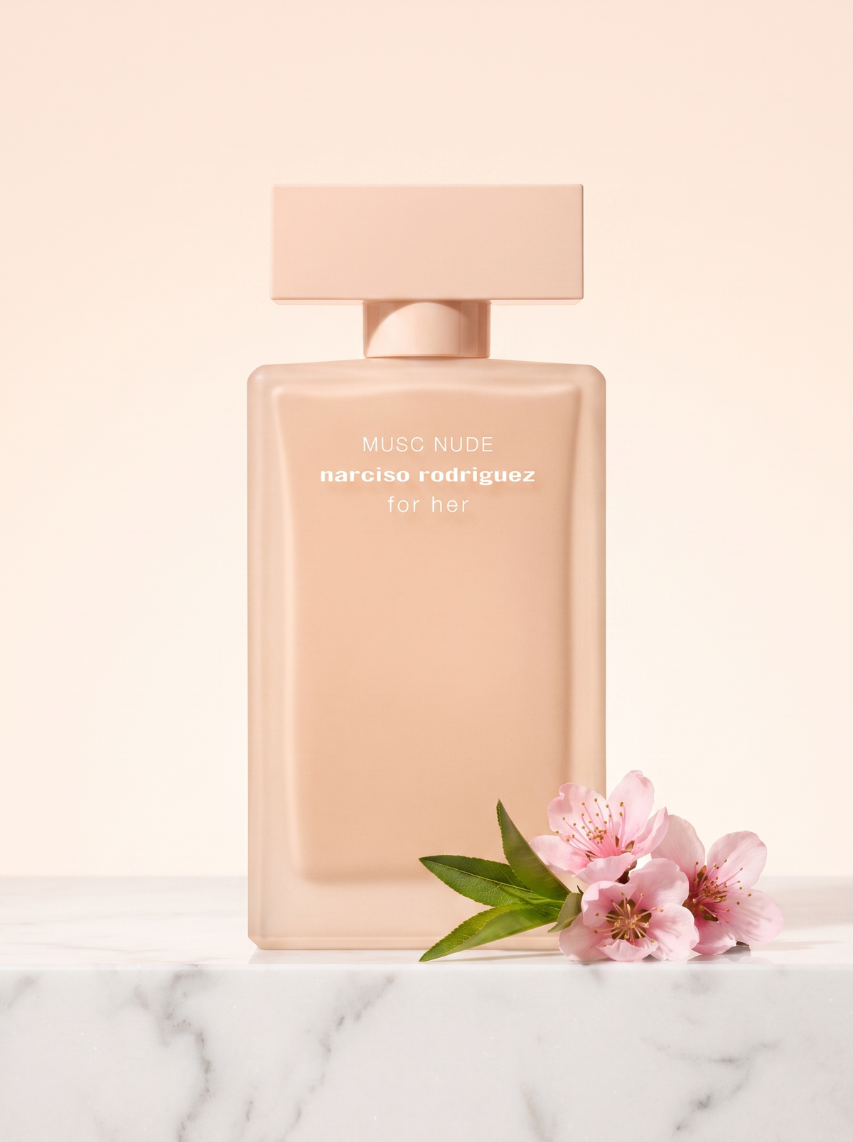 Narciso Rodriguez Musc Nude Eau de Parfum 100 ml - Flakon auf hellem Marmor mit Pfirsichblueten
