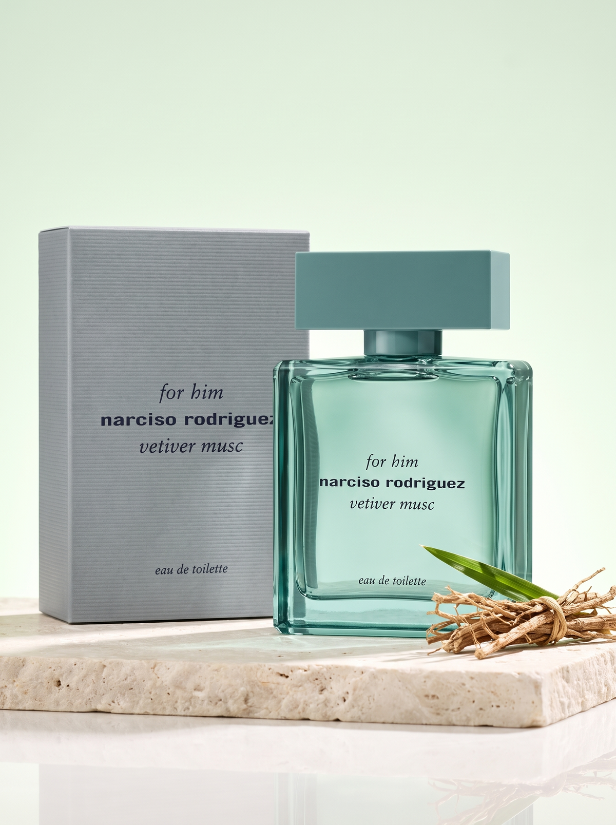 Narciso Rodriguez for Him Vetiver Musc Eau de Toilette 100 ml - gruener Flakon mit Verpackung auf hellem Stein mit Vetiver
