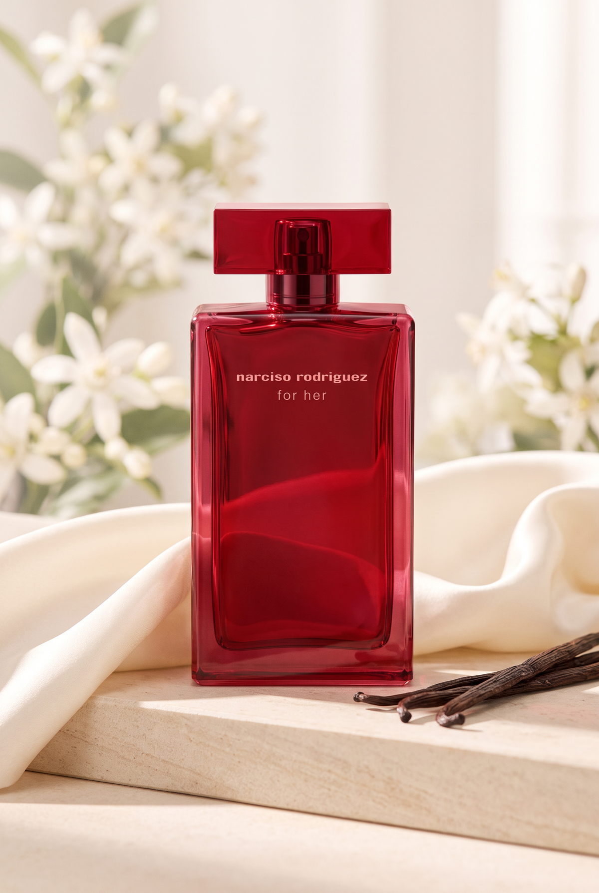Narciso Rodriguez for Her Eau de Parfum in tiefrotem Flakon auf heller Sandstein-Ablage mit Seide und Vanilleschoten - kaufenparfum.de