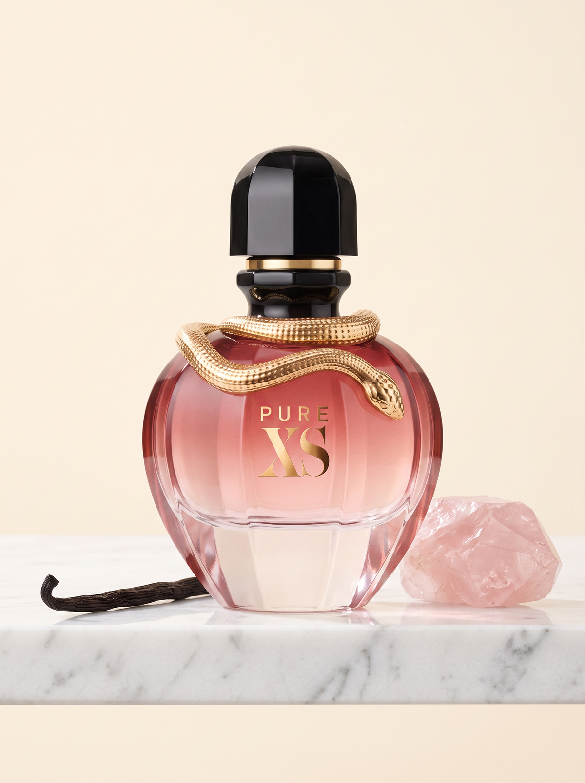 Rabanne Pure XS for Her Eau de Parfum 50 ml - rosa Flakon mit goldener Schlange auf weissem Marmor mit Vanille und Rosenquarz
