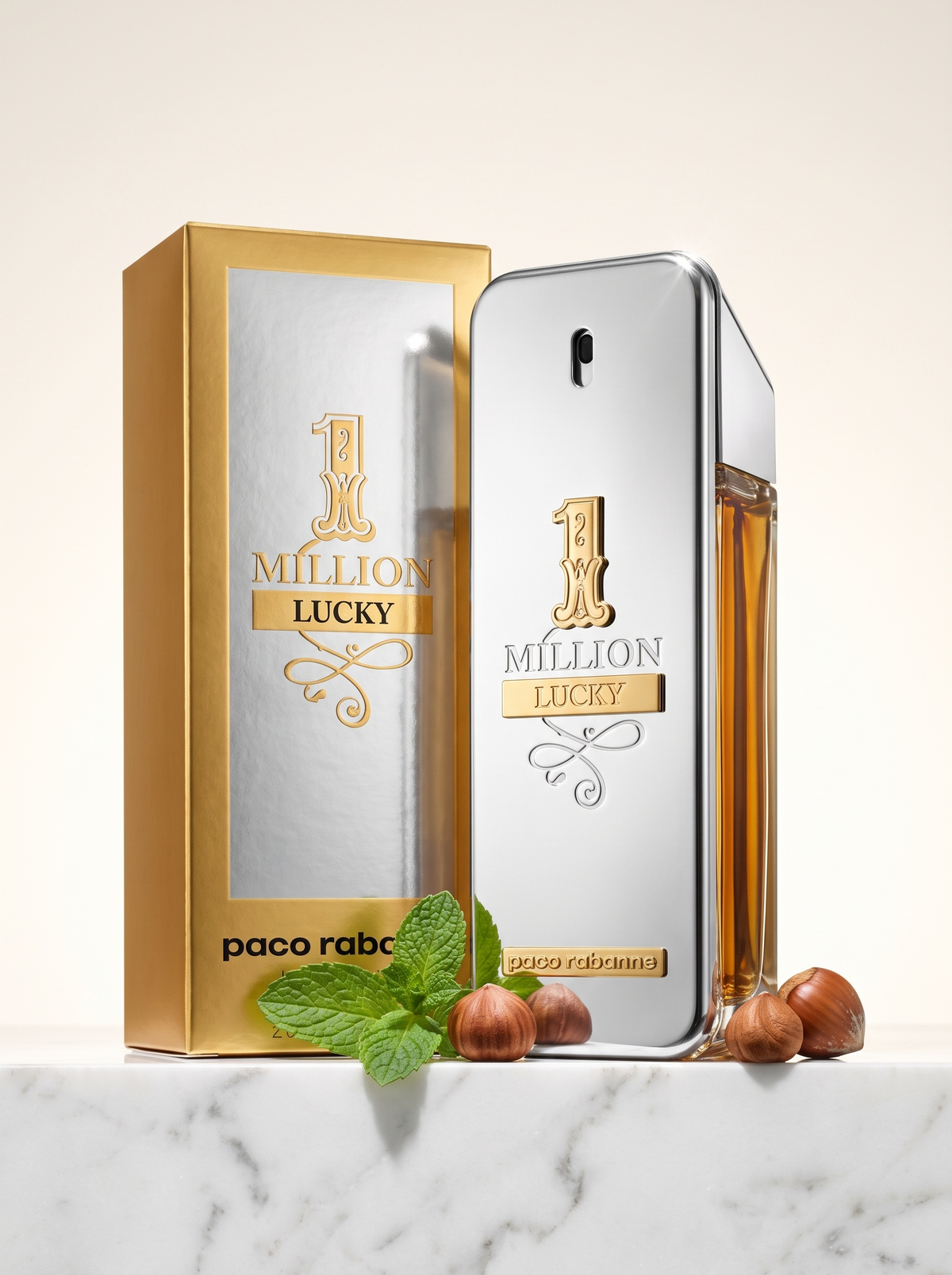 Paco Rabanne 1 Million Lucky Eau de Toilette 100 ml - silberner Flakon mit Verpackung auf hellem Marmor mit Haselnuss