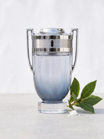 Rabanne Invictus Eau de Toilette 200 ml - Pokal-Flakon auf hellem Beton mit Lorbeer und Meersalz