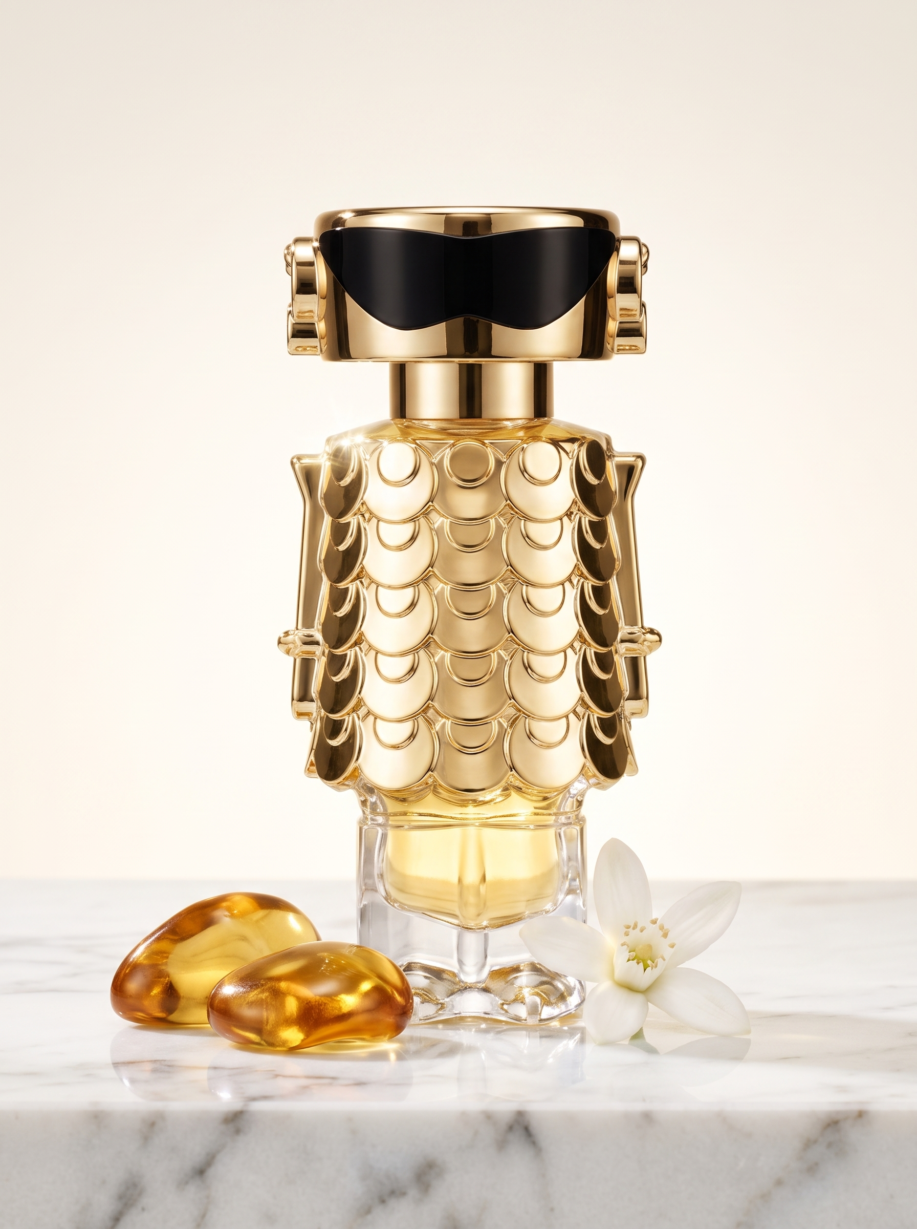 Paco Rabanne Fame Eau de Parfum 30 ml - goldener Figur-Flakon auf hellem Marmor mit Bernstein