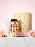 Paco Rabanne Fame Eau de Parfum Geschenkset - goldener Figur-Flakon mit Bodylotion und Metalldose auf hellem Marmor