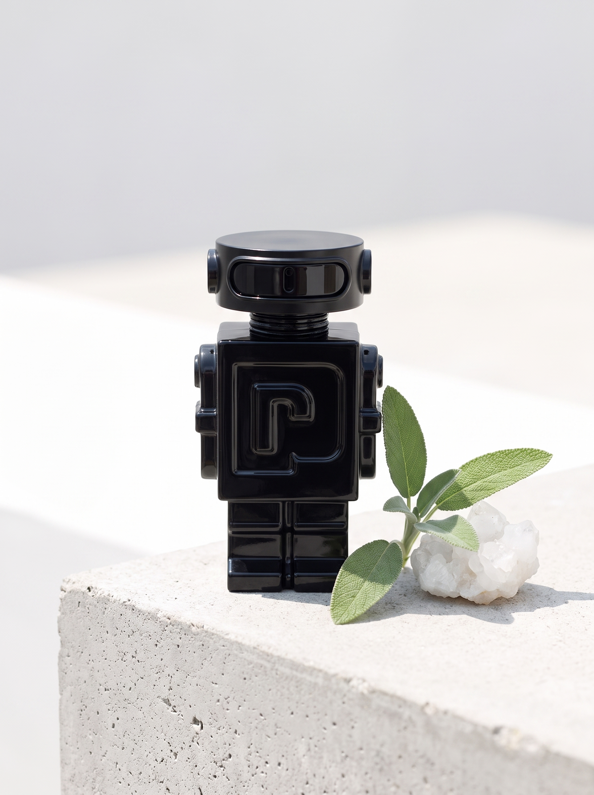 Rabanne Phantom Eau de Parfum 50 ml - schwarzer Roboter-Flakon auf hellem Beton mit Salbei