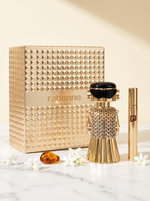 Rabanne Fame Eau de Parfum Geschenkset - goldener Figur-Flakon mit Reisespray auf weissem Marmor mit Jasmin