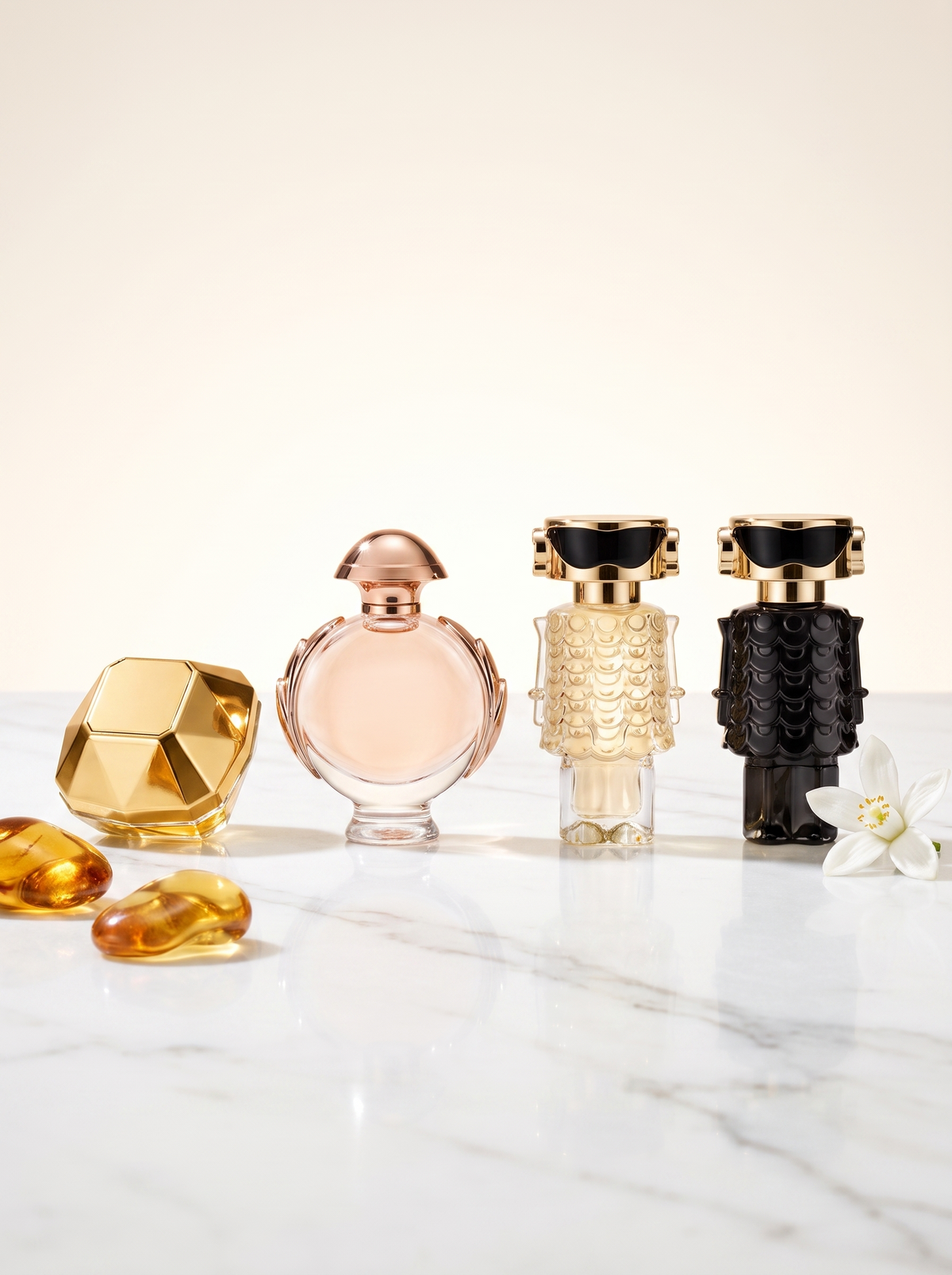 Paco Rabanne Miniaturen Geschenkset 4-teilig - vier Mini-Flakons auf hellem Marmor mit Bernstein