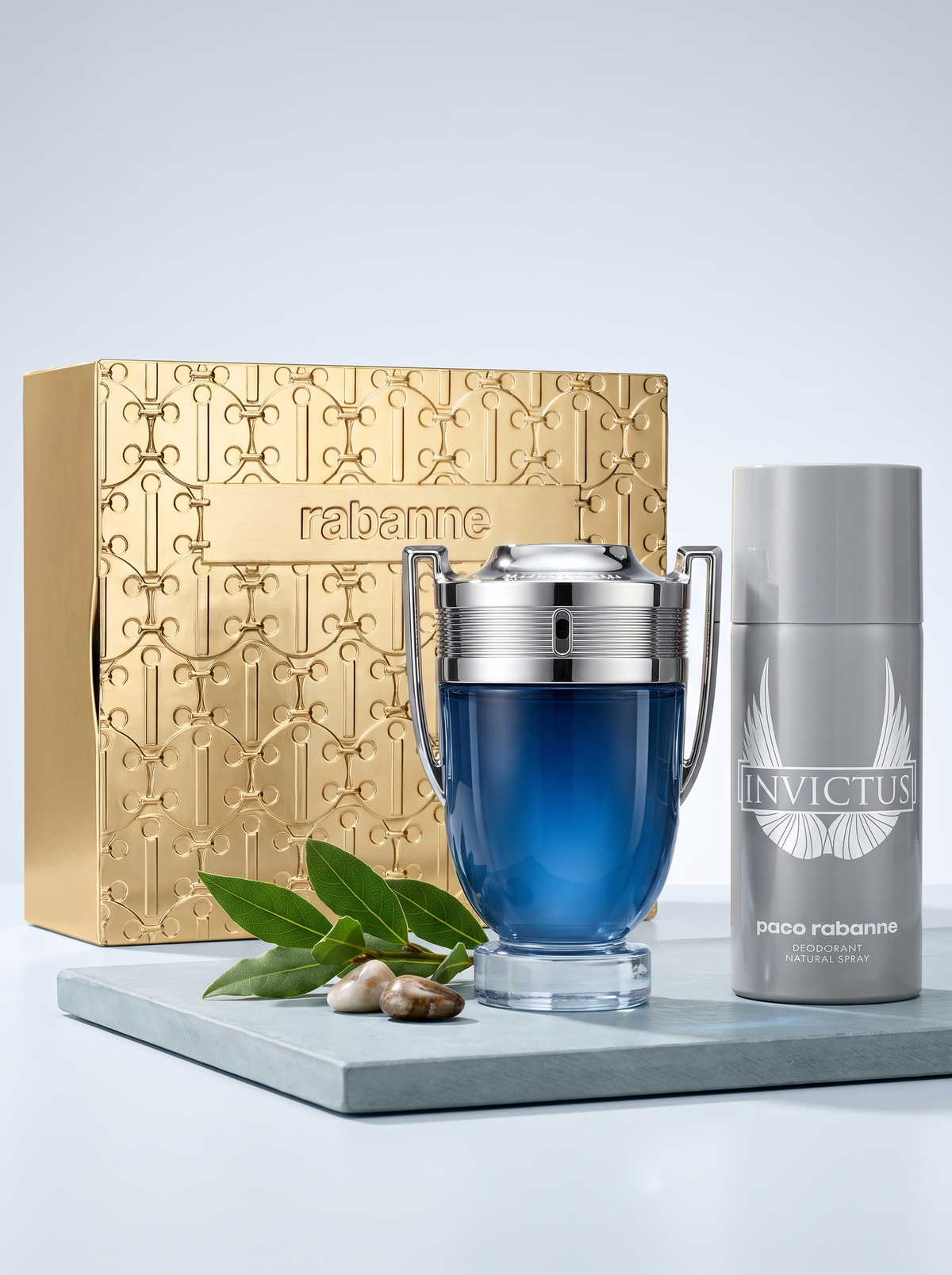 Paco Rabanne Invictus Eau de Toilette Geschenkset - Pokal-Flakon und Deodorant mit Verpackung auf hellem Schiefer